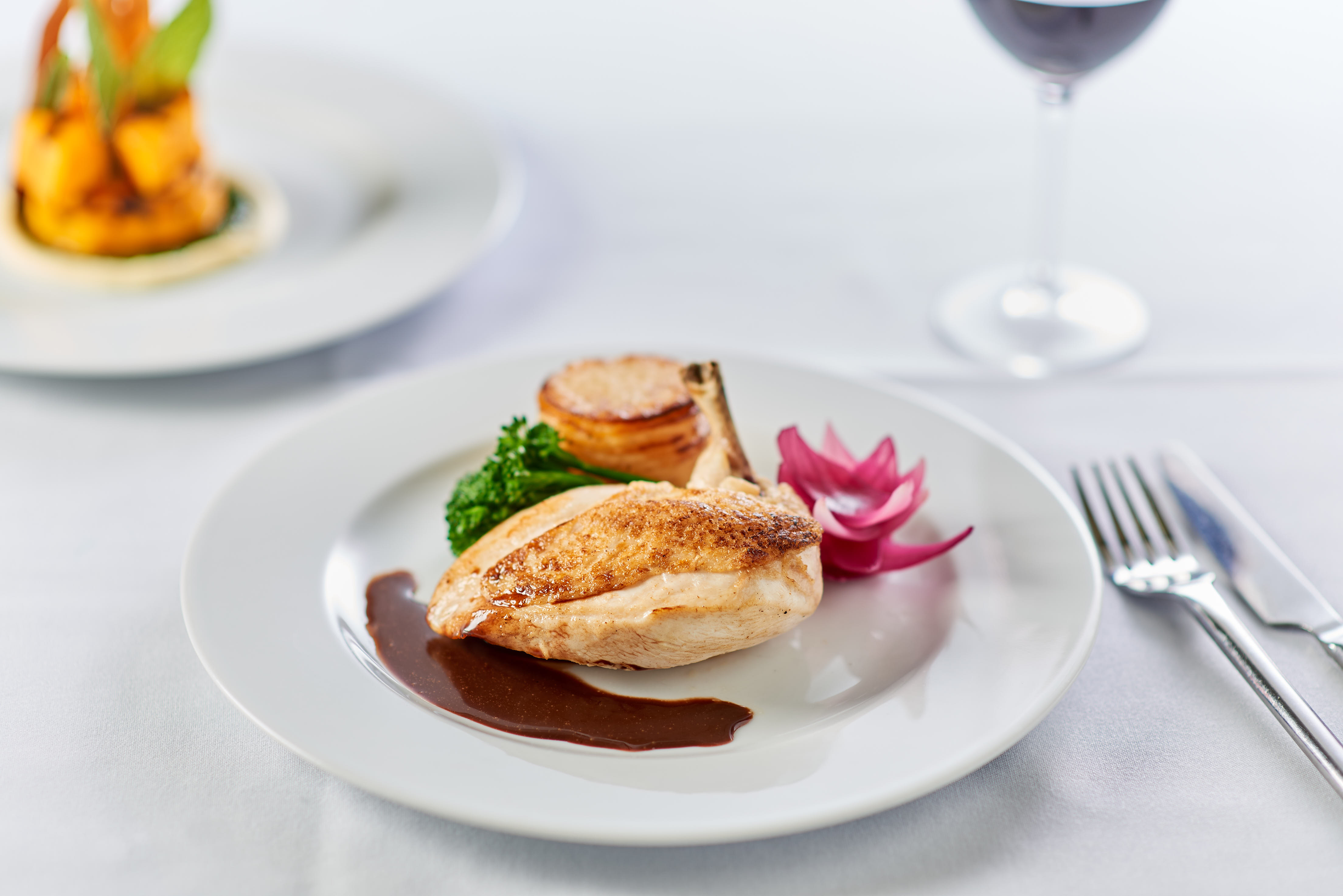 Pink Food's roast chicken breast with red wine jus, Pommes Anna, tenderstem broccoli, and red onion petal